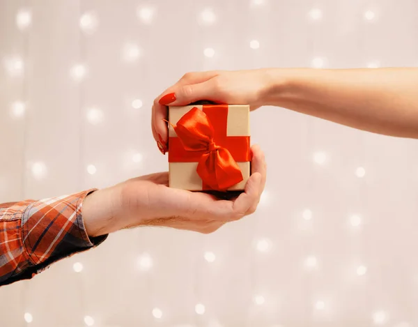 Mains masculines et féminines tenant ensemble une boîte cadeau . — Photo