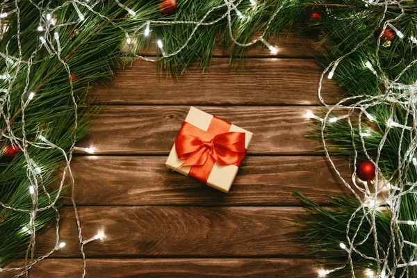 Scatola regalo di Natale con nastro rosso su sfondo di legno. — Foto Stock