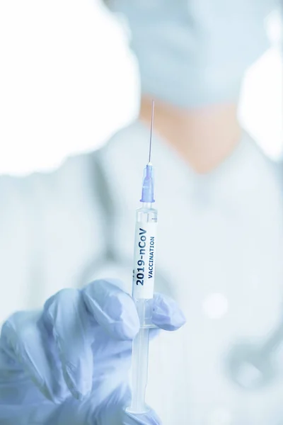 Лікар в захисних рукавичках тримає шприц з вакцинацією 201 — стокове фото