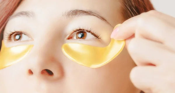 Young Woman Applying Golden Collagen Mask Patch Eye Aging Skin — Stock Photo, Image