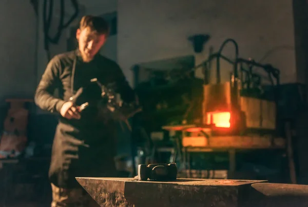 Smid Jongeman Werken Smederij Een Aambeeld Met Hamer Gereedschap Voorgrond — Stockfoto