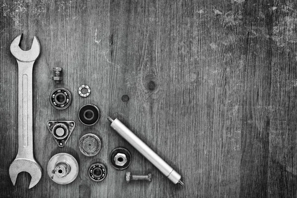 Schraubenschlüssel und Maschinenteile auf grauem Hintergrund. — Stockfoto
