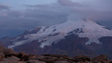 Şafakta Elbrus Dağı 'nda, zaman ayarlı. Rusya, zaman ayarlı. Kafkasya Dağları 'ndaki Elbrus volkanı üzerinde bulutların hareketi. 4 bin. Kimse..