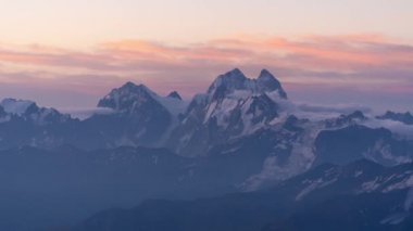 En yüksek karlı dağda, yüzen bulutlarda gün doğumu. 4K 'da çok güzel bir zaman dilimi. Kimse..
