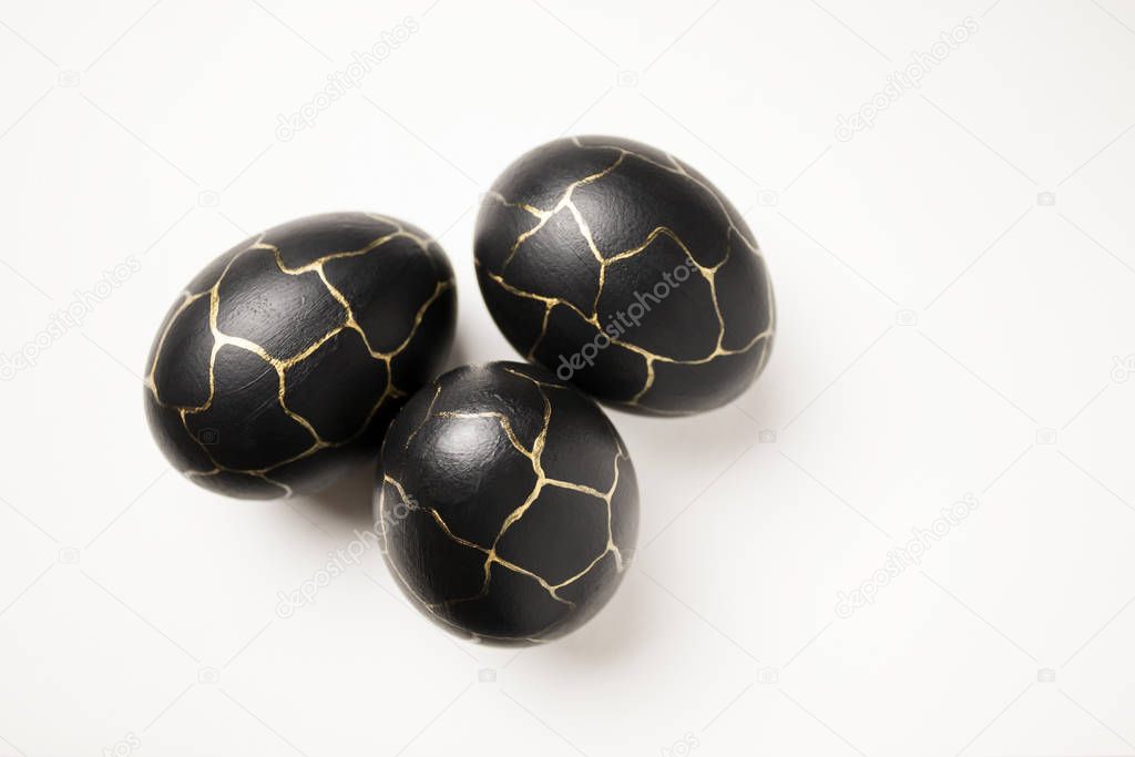 Eggs painted black with gold lines. 