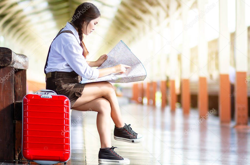 Asian woman pregnant sit on the bench look at the map with red s