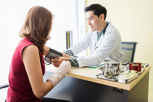 Asiático Jovem médico com medir a pressão para o braço de — Fotografia de Stock