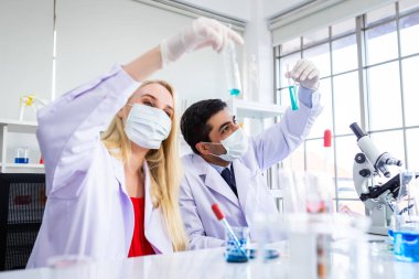 İki bilimadamı Sam 'le birlikte test tüpünü inceliyor.