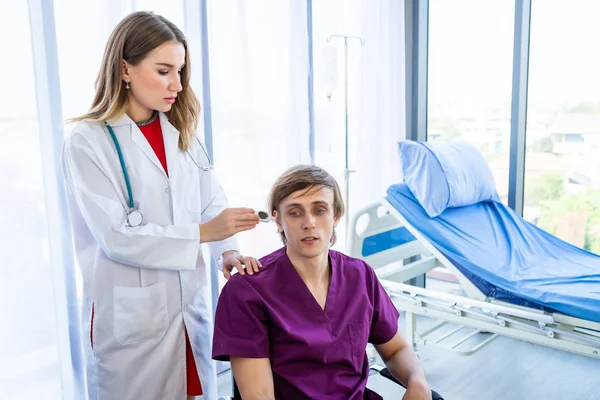 Female doctor checking man patient's temperature in the ear with — 스톡 사진