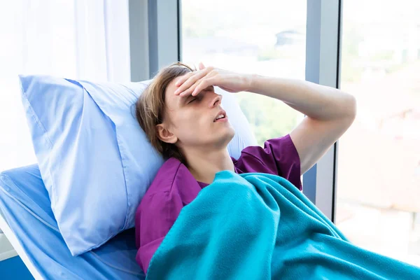 Um homem paciente tem dor de cabeça e tem uma febre com cara de ansiedade l — Fotografia de Stock