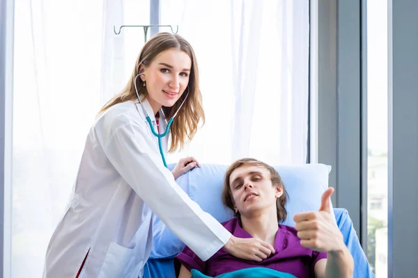 Een man patiënt op bed show tonen duimen omhoog met smiley gezicht ver — Stockfoto