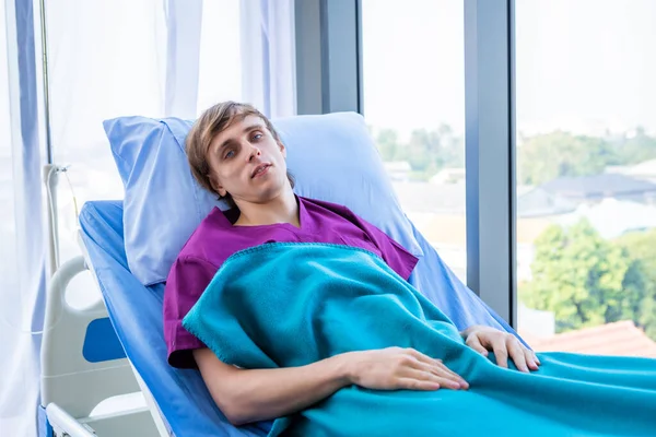 Um um paciente homem com cara de ansiedade deitado na cama no quarto ho — Fotografia de Stock