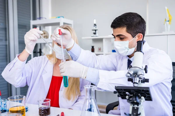 Dos científicos están trabajando en la celebración mirando tubo de ensayo con Sam — Foto de Stock