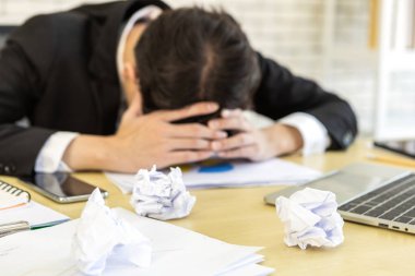 Stresli iş adamı dizüstü bilgisayarla çalışıyordu.