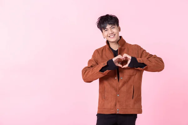 Asiático um homem bonito jovem sorrindo feliz mostrando em forma de coração ha — Fotografia de Stock