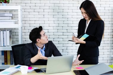 Şirket yöneticisi genç Asyalı iş adamı ve kişisel sekreter yardımcısı iş ortakları koçluğu yaparken aynı zamanda dizüstü bilgisayar ve ofis kârında iş stratejisi ile birlikte çalışırlar..