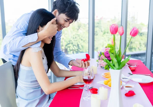 バレンタインデーとアジアの若い幸せな甘いカップルのコンセプト 婚約指輪を持つアジアの男昼食後の女性との結婚の提案レストランの背景では 花嫁と新郎新婦の結婚式の計画 — ストック写真