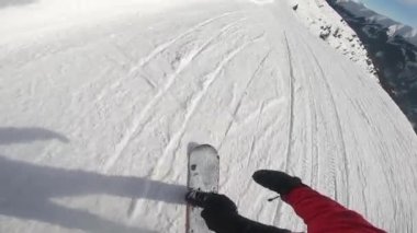 Tepeden aşağıya snowboardcu bayırları. Aksiyon kamerası snowboardcuların kaskını gösteriyor.