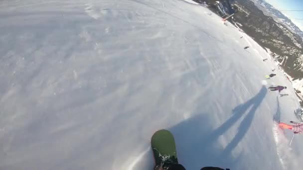 Snowboard sporcusu tepenin aşağısında. Snowboard sporcusunun gölgesi. İLK KİŞİ — Stok video