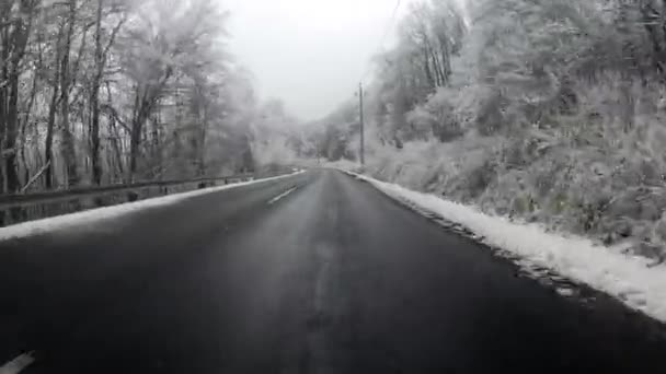 Vehicle driving trough scenic mountian road in winter — Stock Video