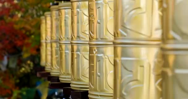 Bhuddhist prayer wheel golden inscribed with a sanskrit prayer and creamy bokeh . — 图库视频影像