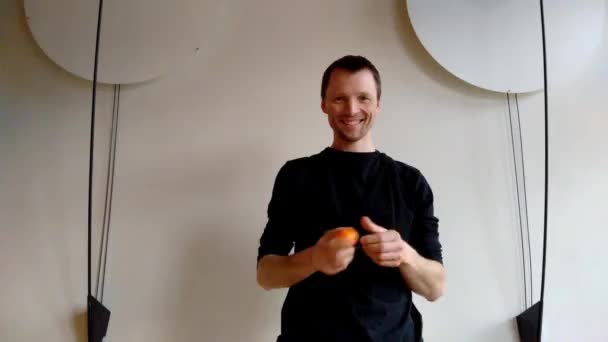 Juggler avec trois boules de couleur avant mur blanc avec décoration sur les côtés — Video