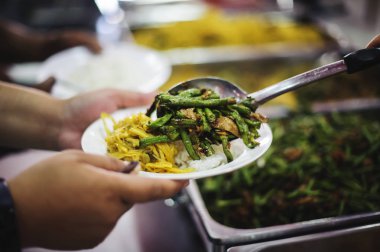 Dilenciler, toplumdaki cömertlerin yardımıyla yiyecek alır: umut ve yiyecek ihtiyacı kavramı.