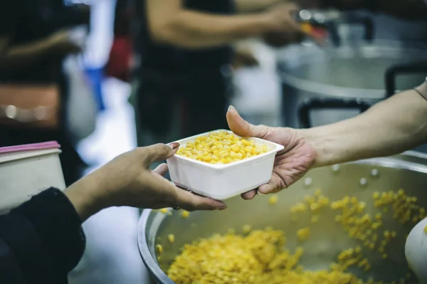 Starving homeless people receive food from volunteers who serve humane: the concept of giving with care