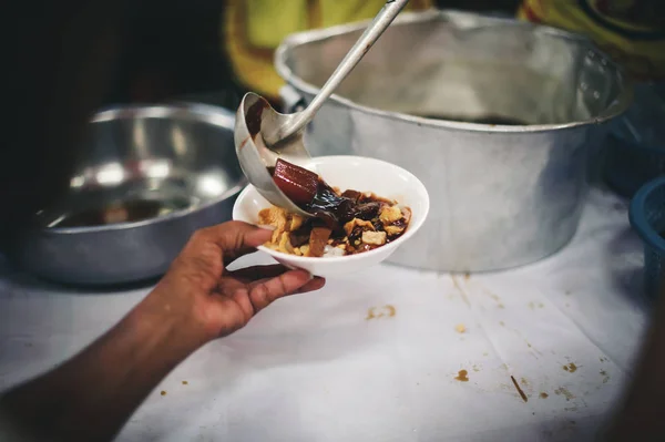 Starving homeless people receive food from volunteers who serve humane: the concept of giving with care