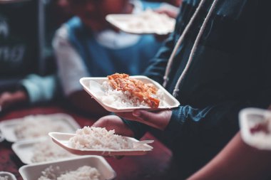 Fakirlerin elleri, gönüllülerden yiyecek alabilmek için bir tabak uzattı. Evsizlere yardım etme kavramı..