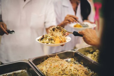 The hands of the poor apply for food from rich people who donate food.