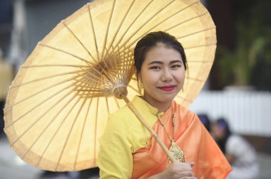 CHIANG MAI, THAILAND - FEBRUARY 08, 2020: Traditionally dressed woman in procession on Chiang Mai 44th Flower Festival in Chiang Mai, Thailand;