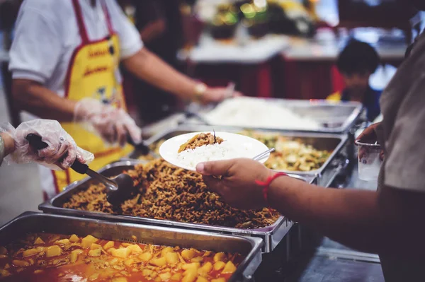 The donor gives warm food to the poor, concept of sharing food to the poor