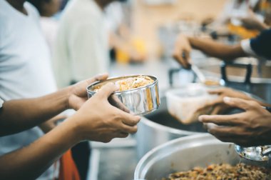 Gönüllüler yoksul insanlara yemek veriyor, açlığı azaltmak için yiyeceklerini paylaşıyorlar.
