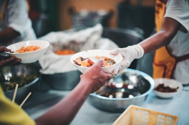 Gönüllüler yoksul insanlara yemek veriyor, açlığı azaltmak için yiyeceklerini paylaşıyorlar.