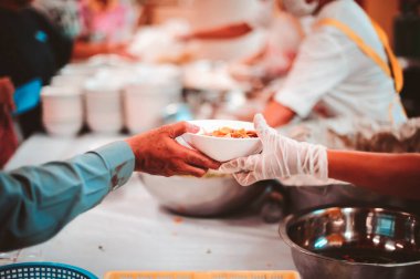 Evsiz ve yardıma muhtaç insanlar, gönüllülerden yiyecek yardımı alıyor: gıda bağışı kavramı.