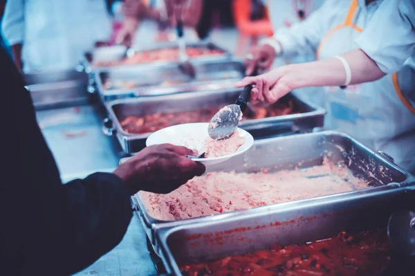 Starving homeless people receive food from volunteers who serve humane : The concept of giving