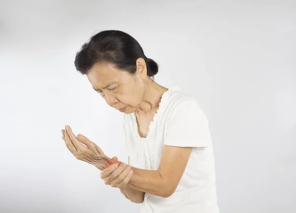 年长的亚洲女人感到手腕肌肉受伤 — 图库照片