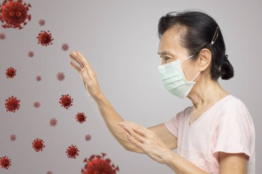 Yaşlı Asyalı kadın antivirüs jestleri ateşlendiğini ve hastalandığını hissettiriyor.