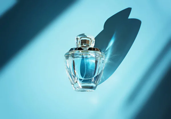 Parfumflesje op lichtblauwe achtergrond — Stockfoto