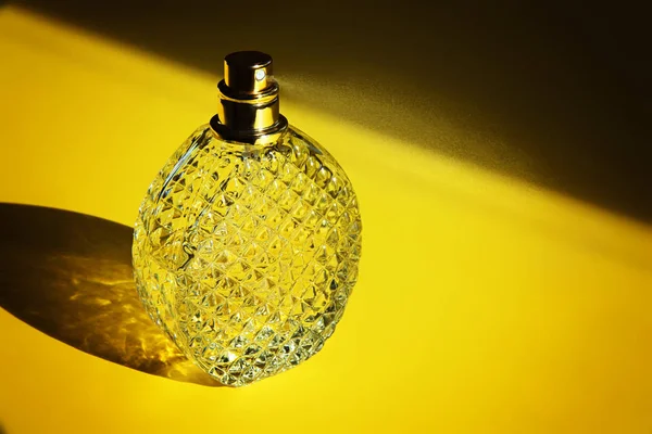 Frasco de perfume no fundo amarelo — Fotografia de Stock