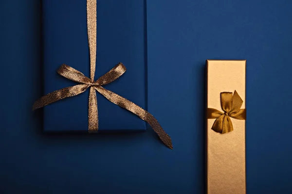 Zwei Geschenkboxen in klassischem blauem und goldenem Papier mit goldenem Band. — Stockfoto