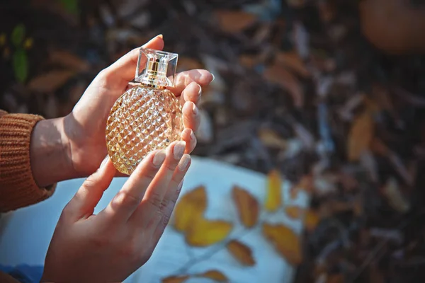 Perfume bottle in female hands