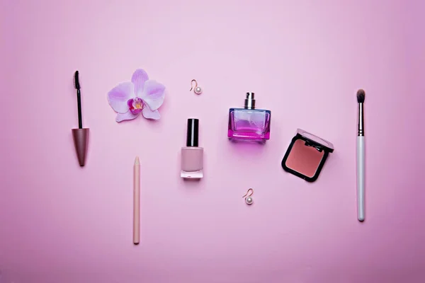 Set of glamorous woman accessories and cosmetics on the pink background.