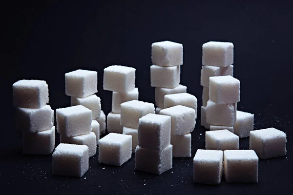 Pile of sugar cubes on a black background. Royalty Free Stock Photos