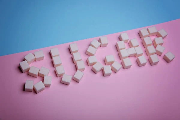 糖分由糖分块制成，背景为粉红色和蓝色. — 图库照片
