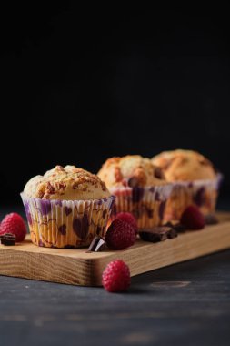 Böğürtlen ve çikolatayla süslenmiş tahtanın üzerinde üç meyveli çikolatalı kek..