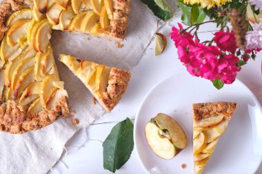 Çamaşır havlusunda dilimlenmiş bir elmalı turta. Beyaz ahşap bir masada tatlı. Üst görünüm.