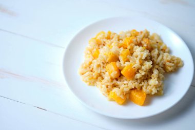 Balkabağı kapaklı risotto. Beyaz masada İtalyan yemeği..