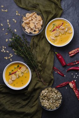 Kabak kremalı çorba, ekmek kırıntıları, acı biber ve kekik, kabak çekirdeğiyle süslenmiş. Üst görünüm.